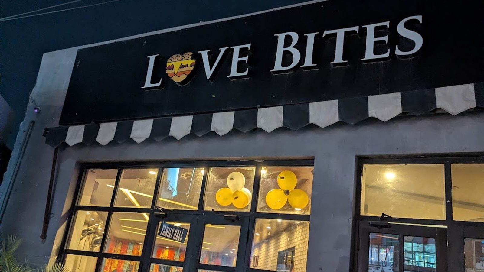 The Love Bites Chiniot shopfront at night, lit sign above the awning on Sargodha Road