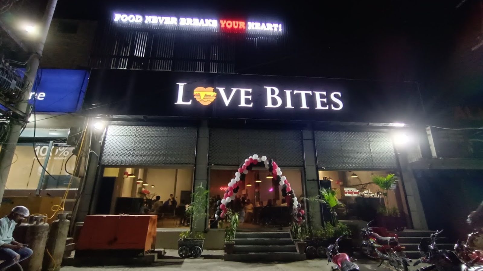 Love Bites Sargodha on Railway Road at night, the words Food Never Breaks Your Heart above the sign